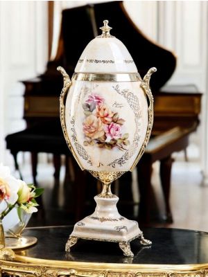Egg-shaped poutiche in fine ceramic, opening lid and floral and gold decorations.