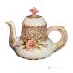 Handmade ceramic teapot in baroque style, decorated with elegant flowers and golden details.